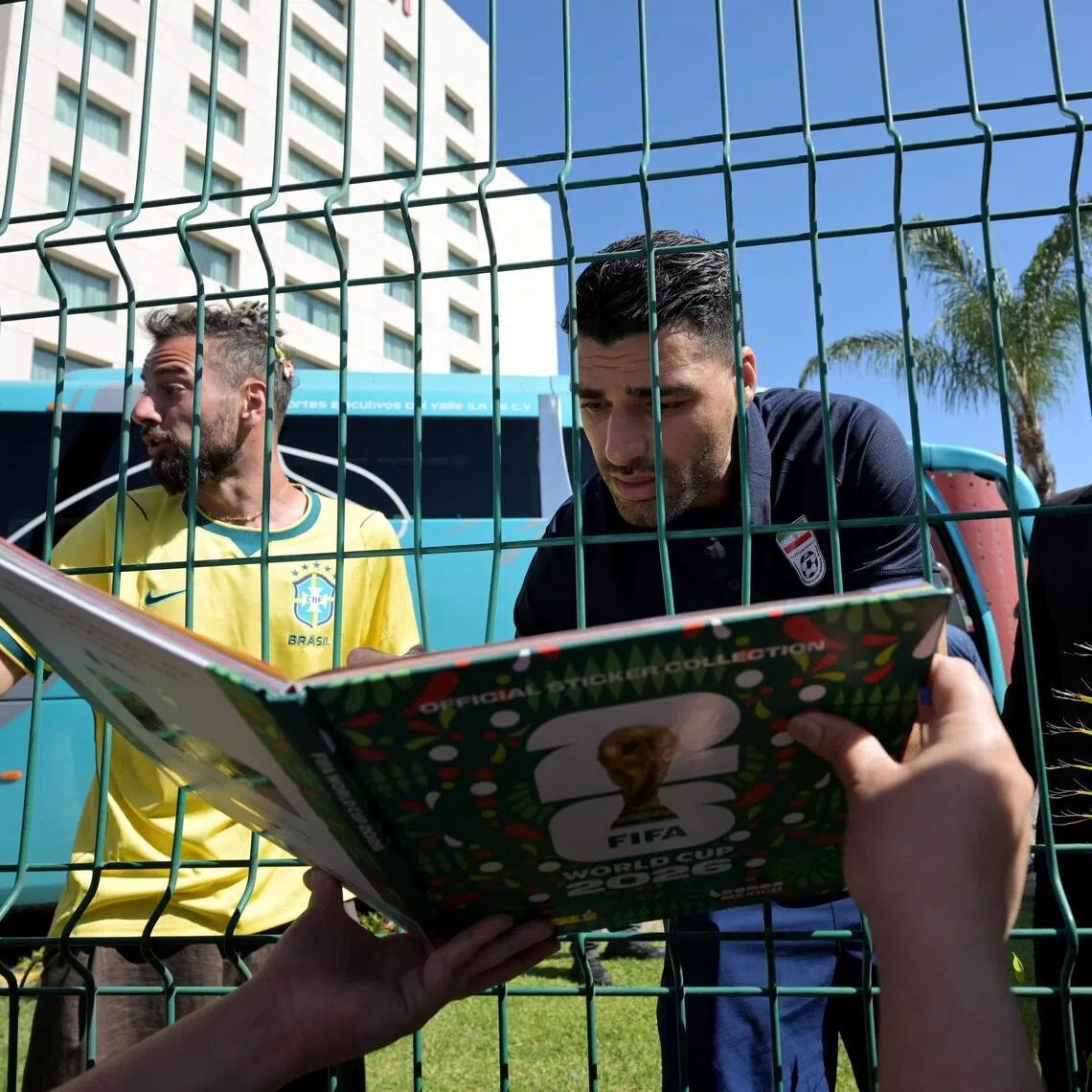 Iran's forward Mehdi Taremi signs autographs for a fan outside the Marriott Hotel in Tijuana, Mexico.