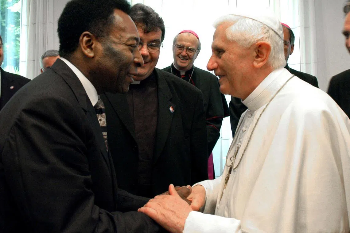 In this picture released by Vatican newspaper L'Osservatore Romano, Pope Benedict shakes hands with Brazilian soccer legend Pele' during their meeting in Cologne, Germany August 20, 2005. 