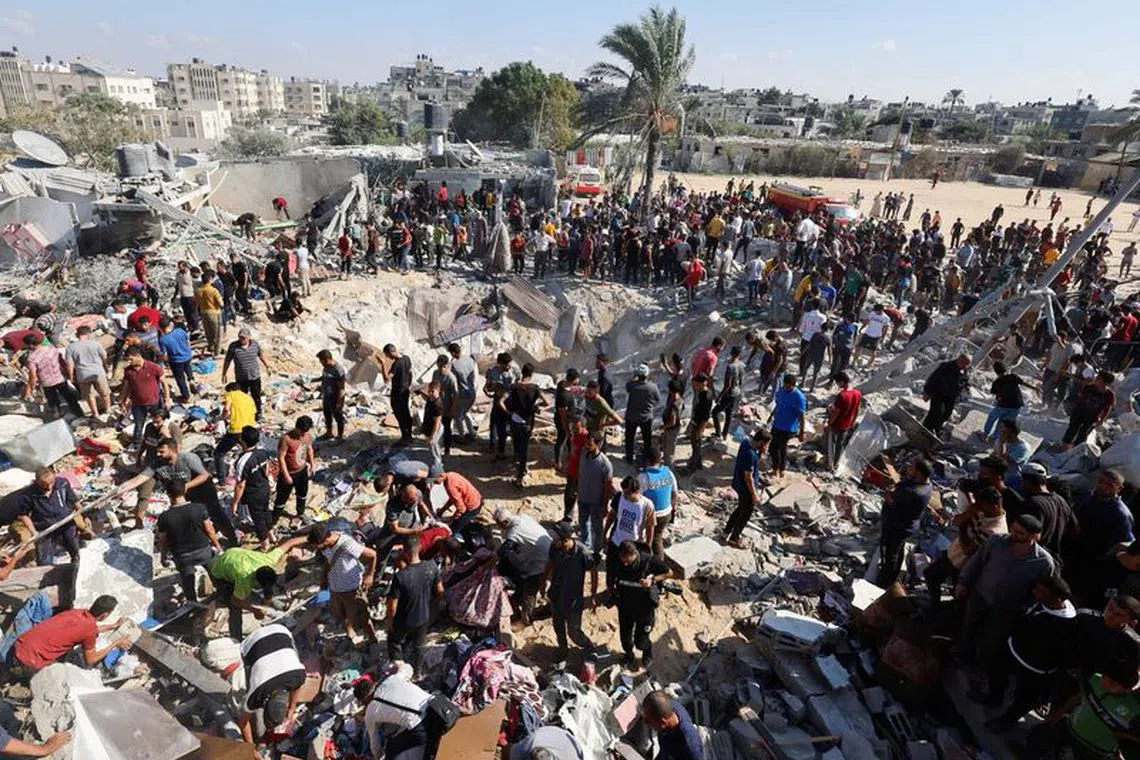 Palestinians search for casualties at the site of an Israeli strike on a house during the ongoing Israeli-Palestinian conflict, in Khan Younis in the southern Gaza Strip October 19, 2023. REUTERS/Mohammed Salem
