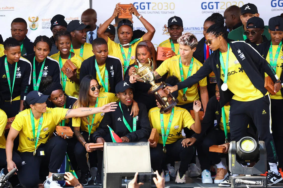 Players of the South African women's soccer team, show off their trophy during their arrival, after winning their first Women's Africa Cup of Nations title in Morocco, at the O.R. Tambo International Airport in Johannesburg, South Africa,  July 26, 2022. REUTERS/Siphiwe Sibeko