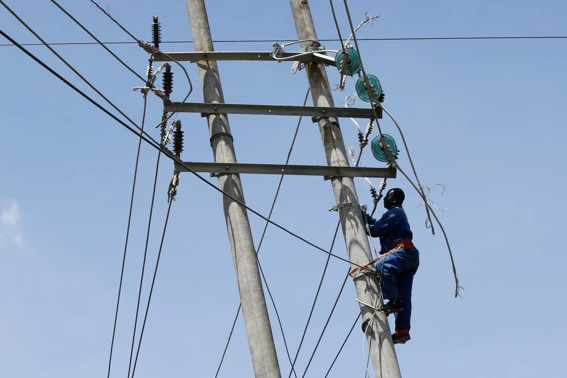 FILE PHOTO: A technician works on the cables of a high voltage electricity transmission pylon from the Kiambere hydroelectric dam in Embakasi district of Nairobi, Kenya January 12, 2022. REUTERS/Monicah Mwangi/File Photo