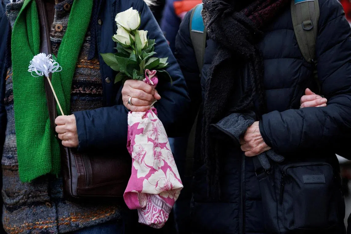 FILE PHOTO: A person holds white roses as people take part in a cross-faith peace march attempting to bridge divisions over the conflict between Israel and the Palestinian Islamist group Hamas, which is causing rising levels of Islamophobia and antisemitism, in London, Britain, January 21, 2024 REUTERS/Belinda Jiao/File Photo