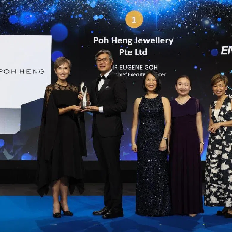 Poh Heng Jewellery group CEO Eugene Goh (second from left) receiving the top accolade at this year's Enterprise 50 Awards from Minister for Digital Development and Information Josephine Teo (left). 