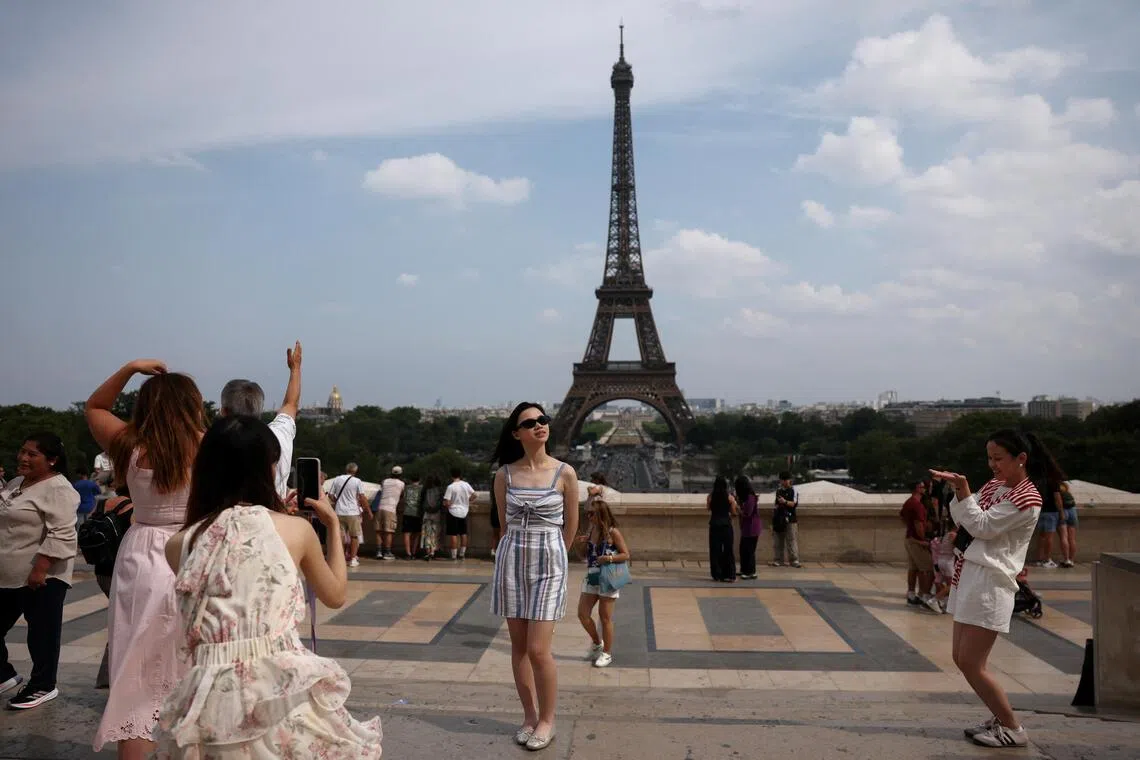 Tourists posing for photos at Trocadero square in Paris, France.