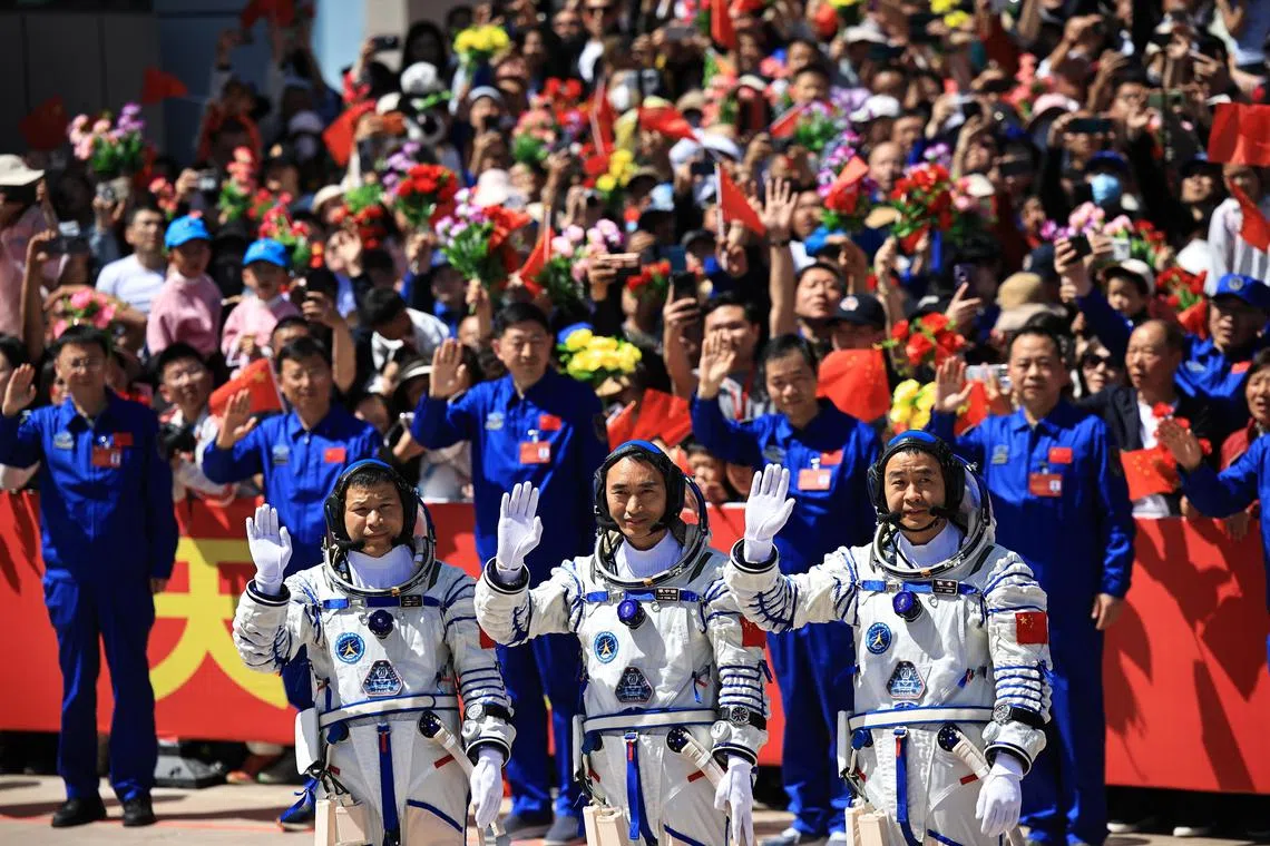 Shenzhou-20 space mission astronauts Chen Zhongrui (C), Chen Dong (R) and Wang Jie, greeting members of the public during the seeing-off ceremony at the Jiuquan Satellite Launch Centre near Jiuquan, China.