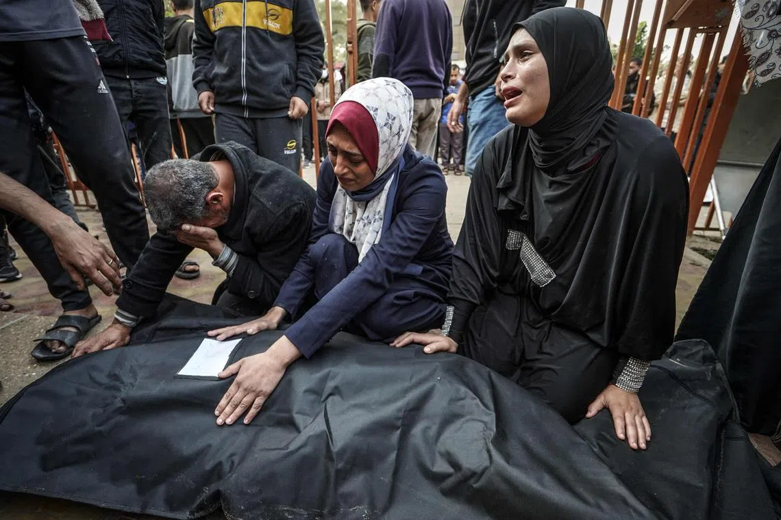Relatives mourn over the body of a loved one killed during Israeli bombardment, at Nasser Hospital in Khan Younis, in the southern Gaza Strip.