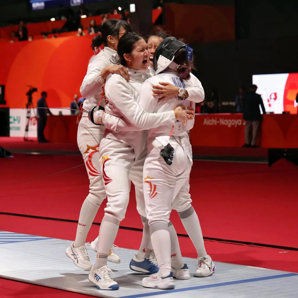 Singapore’s Elle Koh (right) getting mobbed by her teammates after securing a 42-41 win over Uzbekistan in the women’s epee team quarter-finals at the Asian Games on Sept 25, which helped them win a bronze medal.