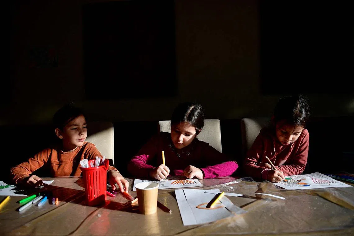 Hasidic Jewish refugee children from Ukraine color Hanukkah drawings at a kosher shelter on the banks of Hungary's Lake Balaton during the first day of Hanukkah in Balatonoszod, Hungary December 18, 2022. REUTERS/Marton Monus TPX IMAGES OF THE DAY