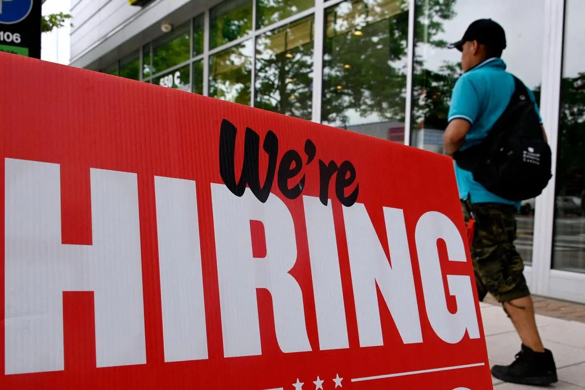 (FILES) A man walks past a "now hiring" sign posted outside of a restaurant in Arlington, Virginia, on June 3, 2022. Private sector hiring in the United States slowed more than expected in August, according to data from payroll firm ADP on August 30, 2023, as a boom from the leisure and hospitality sectors faded. This comes as both segments, which are key drivers of summer hiring, slow into the later part of the year while policymakers keep a close eye on labor market strength as they weigh further interest rate decisions. (Photo by OLIVIER DOULIERY / AFP)