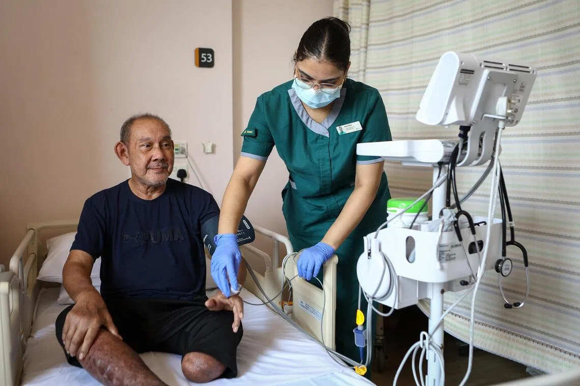 Jumadi Sayap (left) currently resides in the Ren Ci @ Woodlands nursing home, where his daily needs are taken care of by the staff, such as junior community care associate Rajni Bala (right).