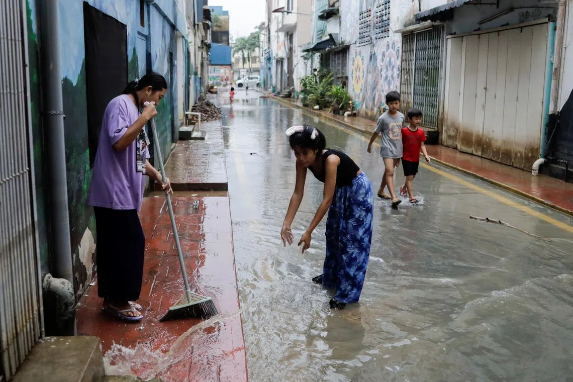People clean the back-alley of shophouse as the floodwaters recede, in Kota Tinggi, Johor, Malaysia March 5, 2023. REUTERS/Hasnoor Hussain