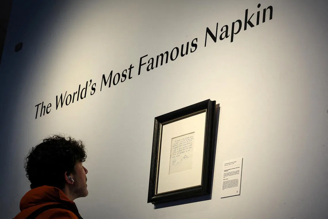 FILE PHOTO: A guest looks at a napkin, written on by Barcelona's Sporting Director at that time Carles Rexach on December 14, 2000, promising a contract to secure 13-year-old Lionel Messi for FC Barcelona, on display at Bonhams Auctions in New York City, U.S., March 6, 2024.  REUTERS/Brendan McDermid/File Photo
