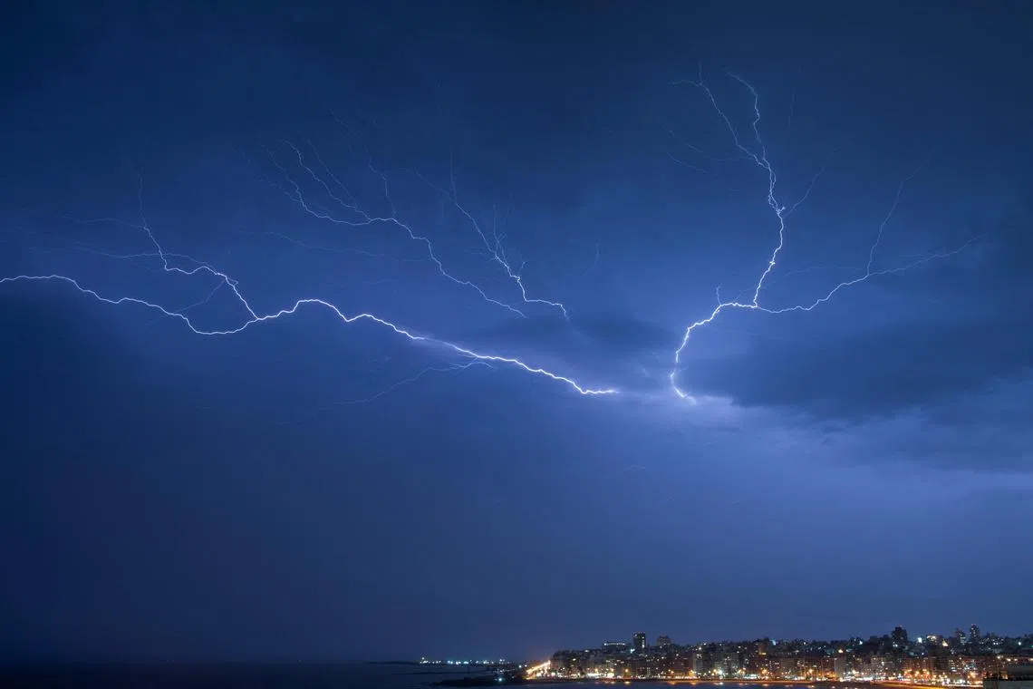 Lightning strikes during a thunderstorm in Montevideo on March 19, 2024. (Photo by Mariana SUAREZ / AFP)