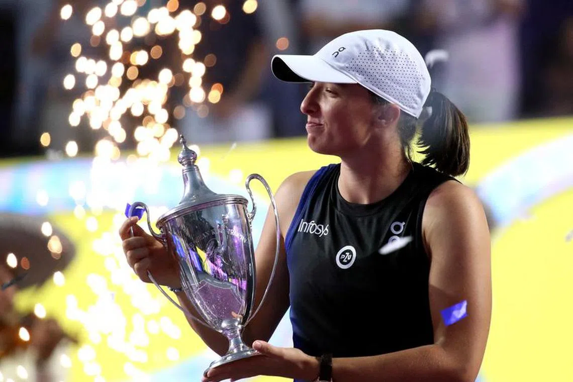 FILE PHOTO: Tennis - WTA Finals - Cancun, Mexico - November 6, 2023 Poland's Iga Swiatek celebrates with the trophy after winning her final match against Jessica Pegula of the U.S. REUTERS/Henry Romero/File Photo