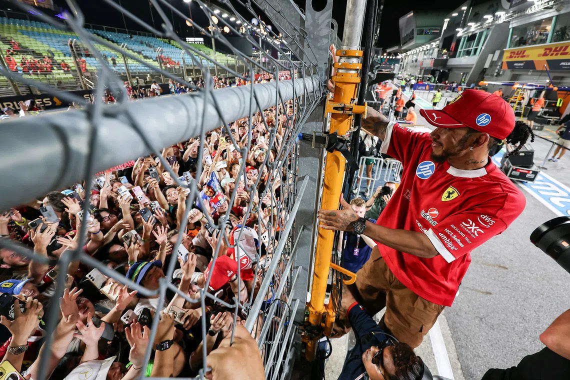 Ferrari’s Lewis Hamilton greets fans on the track after the 2025 Formula One Singapore Airlines Singapore Grand Prix at the Marina Bay Street Circuit on Oct 5, 2025.