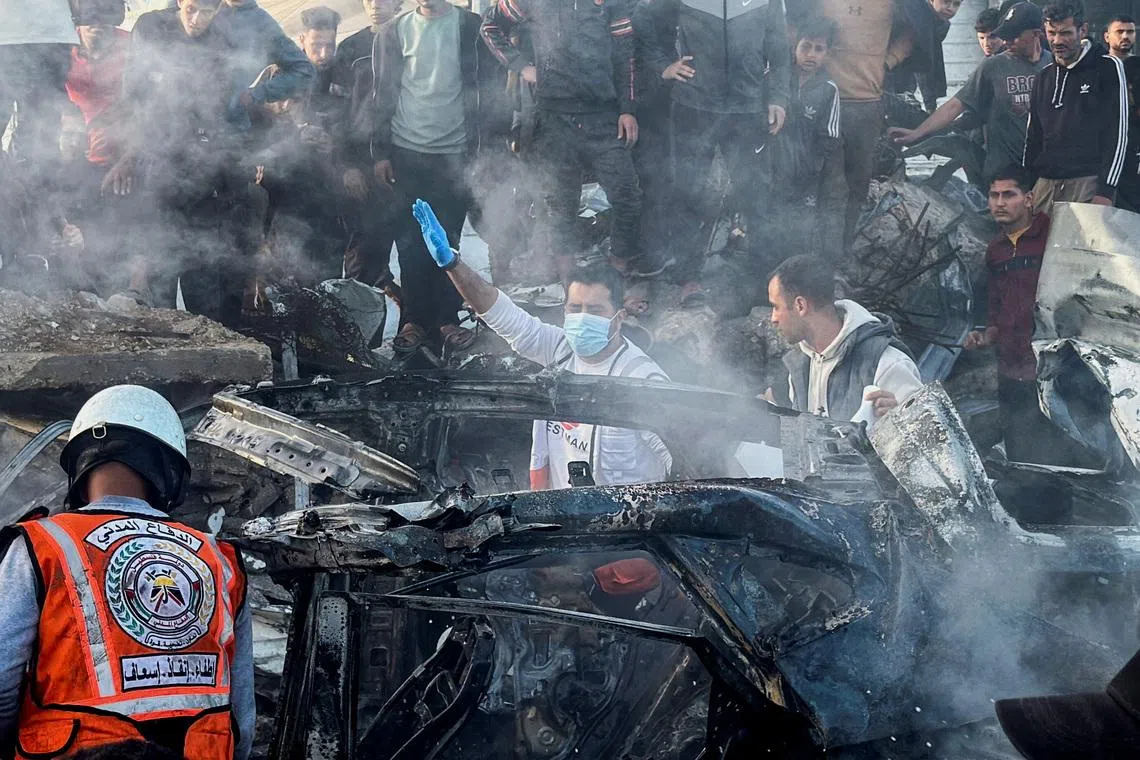 Emergency services work at the site of what medics said was an Israeli airstrike on a car near the entrance to Zawayda town, amid the U.S.-Israeli conflict with Iran, in the central Gaza Strip, April 4, 2026. Picture taken with a mobile phone.  REUTERS/Stringer
