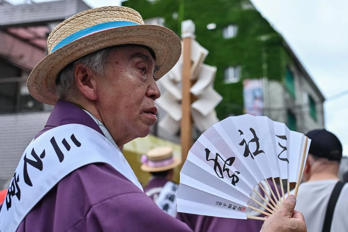 A participant fans himself in the heat as he takes part in the annual Sanja Matsuri Festival in the Asakusa district of Tokyo.