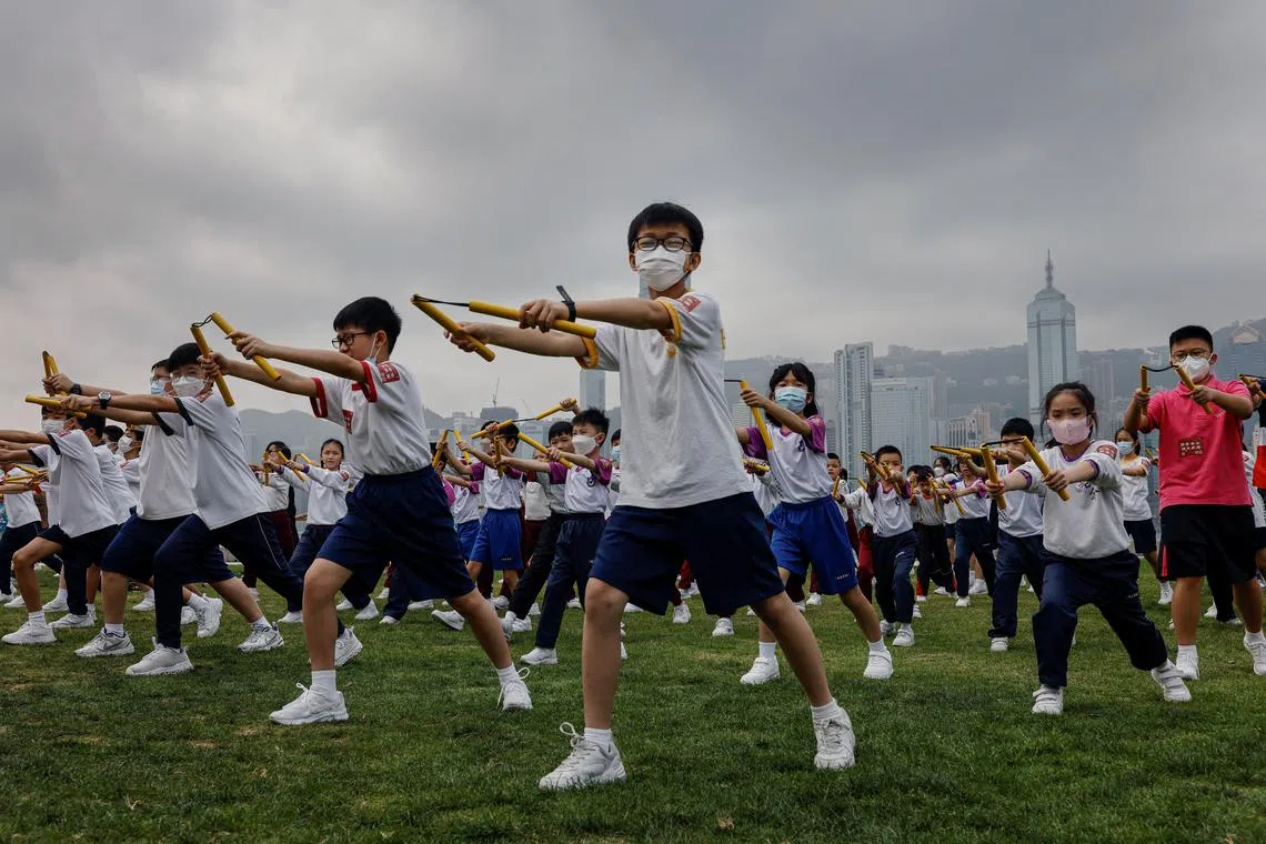 Heung Yee Kuk Yuen Long District Secondary School students attending a nunchaku performance event by the sea, in a tribute to the late martial artist and actor Bruce Lee on April 14. 