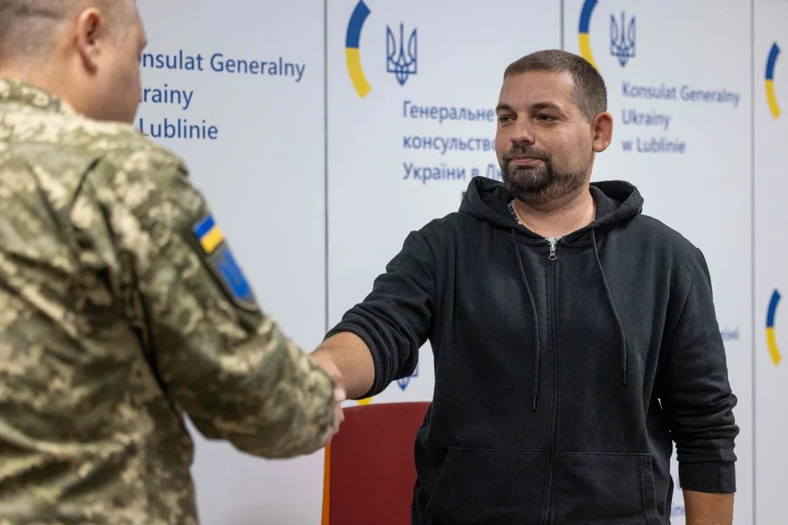 Mr Igor Rusakevych (right), a 37-year-old construction manager, shaking hands with an officer after signing a military contract on Nov 12.