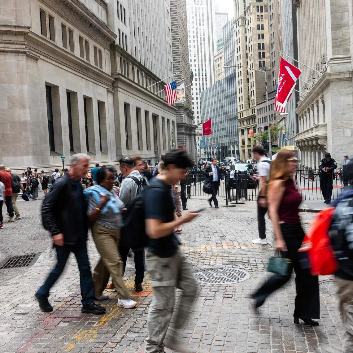 People walking along Wall Street in New York’s financial district on Sept 17. The sector’s employment continued to slide, losing 7,000 jobs in September.
