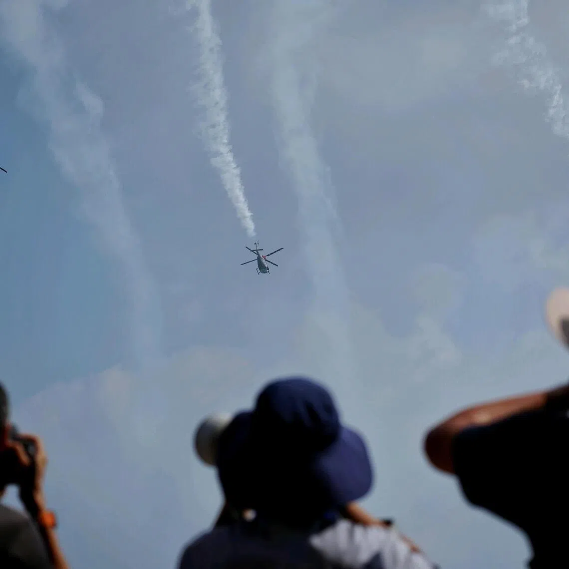 A display of team aerobatics by the Hal Dhruv ALH from Indian Air Force Sarang Helicopter Display Team during the media preview at Changi Exhibition Centre on Feb 1, 2026. ST PHOTO: KEVIN LIM esair01