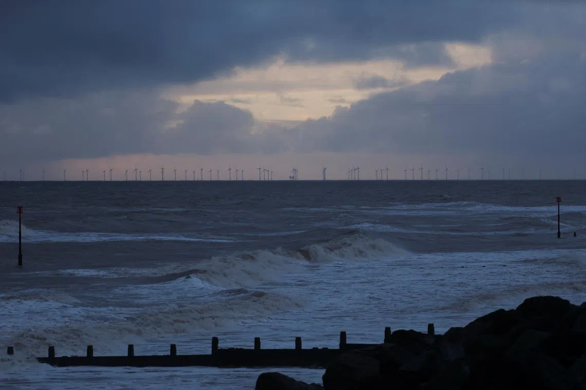 The sun rises behind a windfarm, near the location where a tanker carrying jet fuel for the U.S. military was hit by a container ship, off the coast of Withernsea, Britain, March 11, 2025. REUTERS/Phil Noble