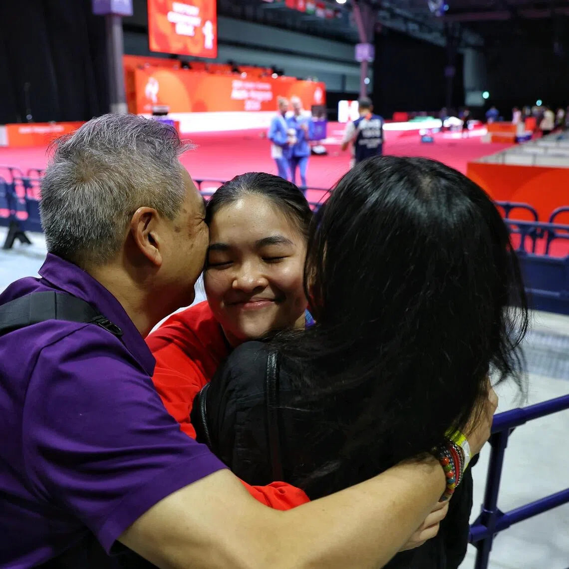Bronze medallist Maxine Wong (centre) of Singapore getting a hug from her father Philip Wong and mother Chan Bee Bee after the medal ceremony for the women’s foil individual during the Asian Games.
