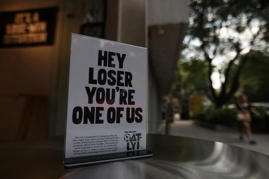 A woman walks in front of Losers Cafe, operated by Swedish dairy-alternative brand Oatly, which opened the cafe in Mexico City to console supporters of teams that lost at the 2026 World Cup with a free drink, in Mexico City, Mexico, June 26, 2026. REUTERS/Quetzalli Nicte-Ha