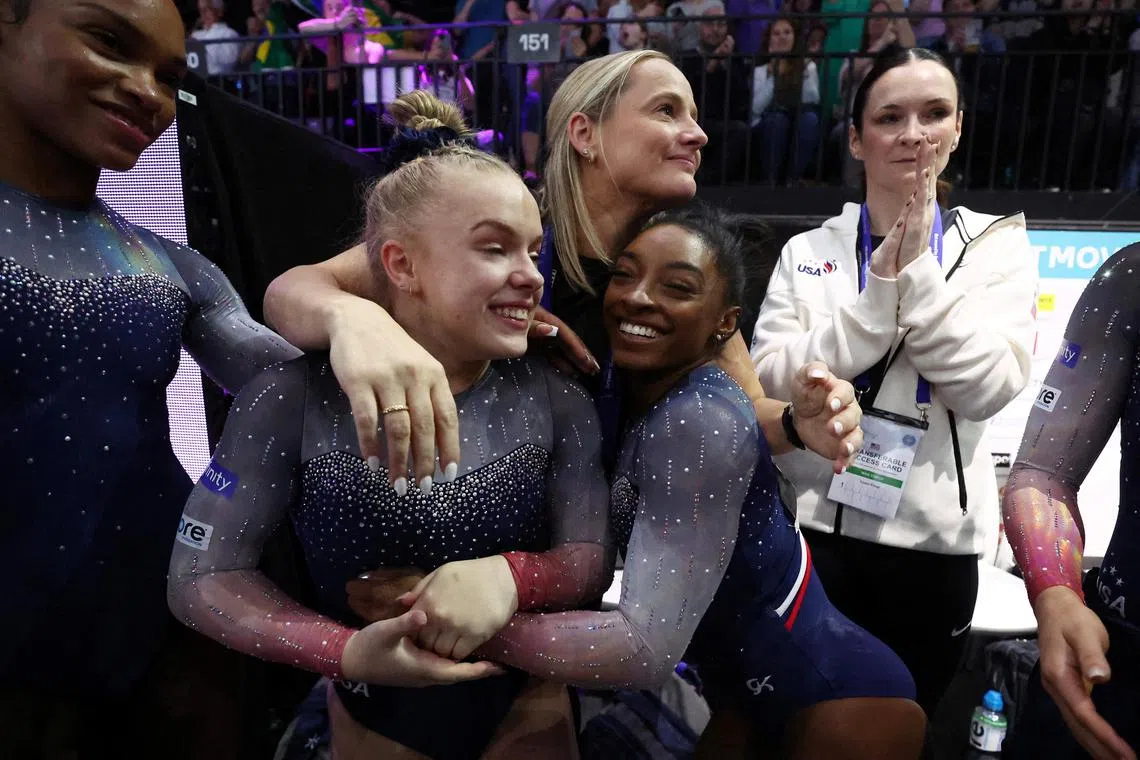 Simone Biles celebrates with teammates after leading the United States to their seventh straight women's team gold at the Gymnastics World Championships.  