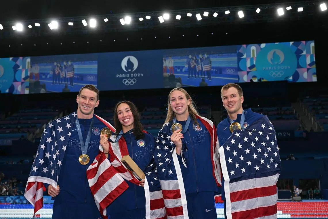 (L-R) Gold medallists Ryan Murphy, Torri Huske, Gretchen Walsh and Nic Fink celebrate during the podium ceremony of the mixed 4x100m medley relay final.