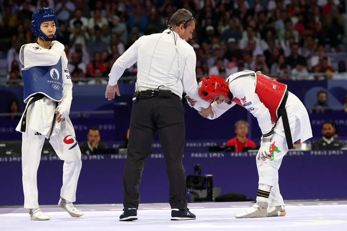 South Korea's Park Tae-joon checks as Azerbaijan's Gashim Magomedov is injured during their Paris Olympics taekwondo men's 58kg final at the Grand Palais on Aug 7, 2024.