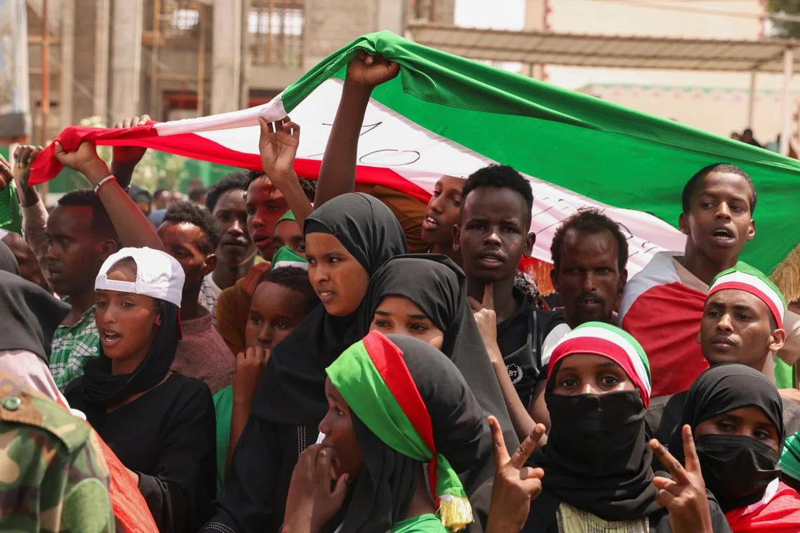 People hold the flag of Somaliland during the parade in Hargeisa, Somaliland, May 18, 2024.