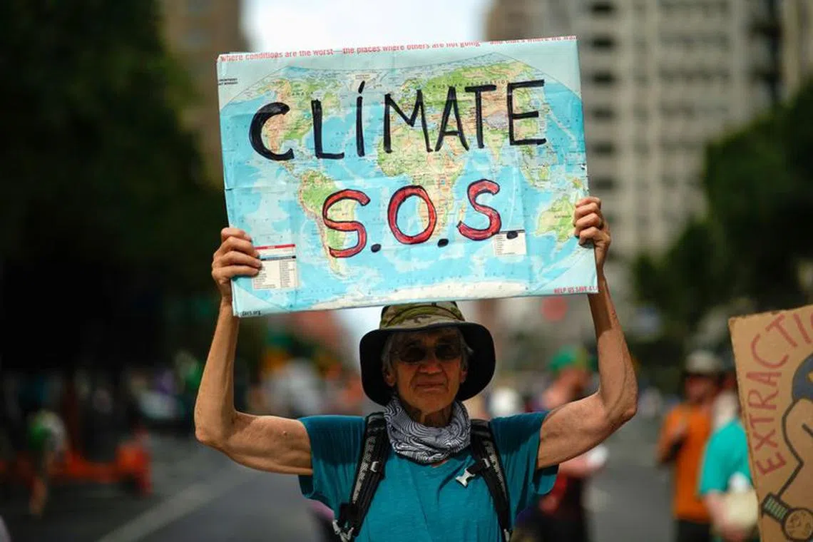 A man holds a sign as activists mark the start of Climate Week in New York during a demonstration calling for the U.S. government to take action on climate change and reject the use of fossil fuels in New York City, New York, U.S., September 17, 2023. REUTERS/Eduardo Munoz/ File photo