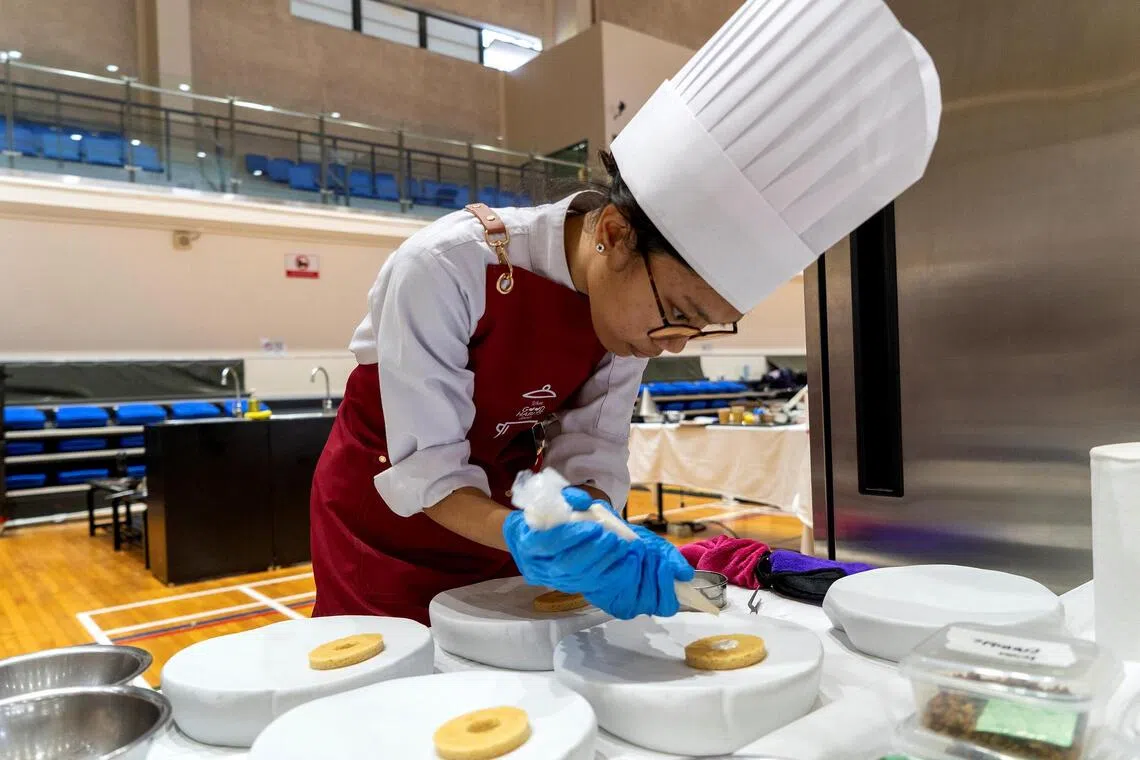 Higher Nitec hospitality student Nur Iman Sulaiman at a cooking competition in May, in which participants were tasked with coming up with meals that incorporated heart-healthy canned ingredients.