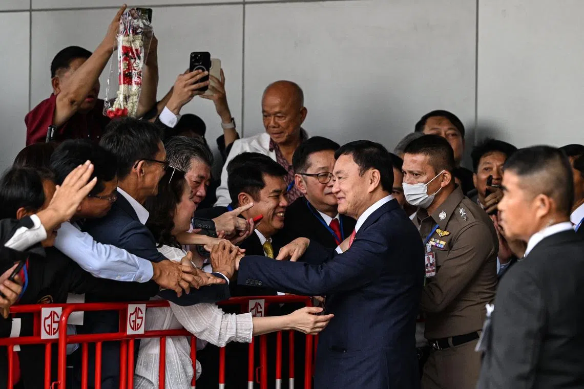 Former Thai prime minister Thaksin Shinawatra greeting supporters after landing at Bangkok's Don Mueang airport on Aug 22.