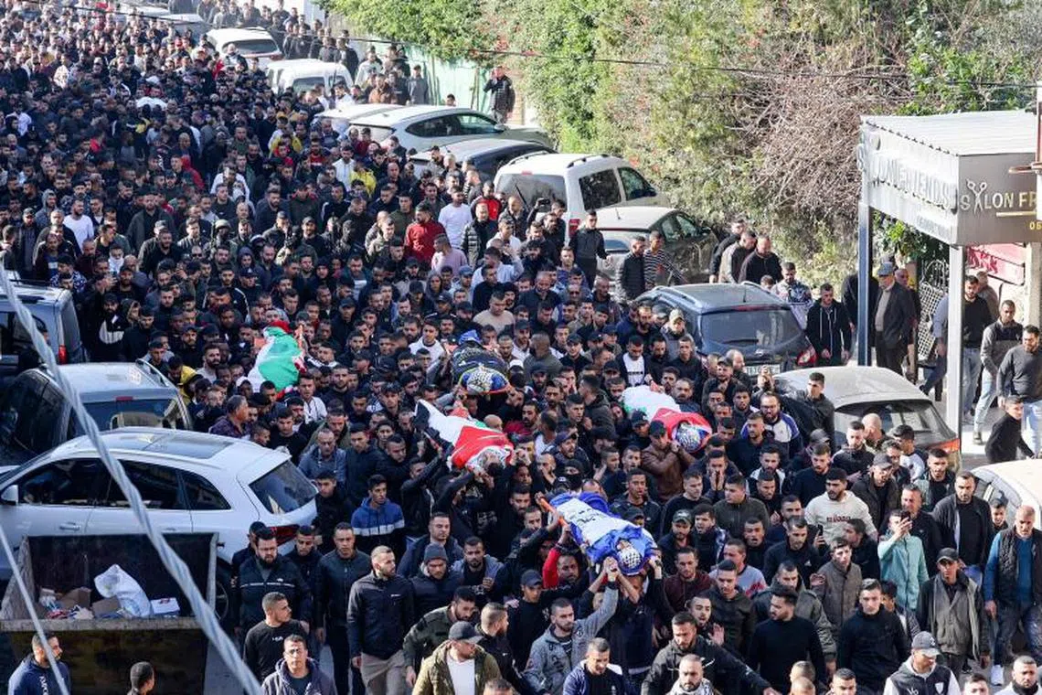 Palestinians carry the bodies of reported victims killed during an Israeli raid on the West Bank's Jenin refugee camp, on Jan 26, 2023.