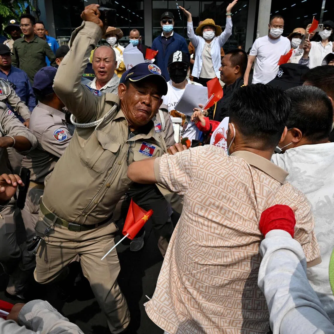 Some demonstrators wielded umbrellas and clashed with scores of local security personnel armed with batons near the National Bank of Cambodia headquarters in Phnom Penh on April 27.