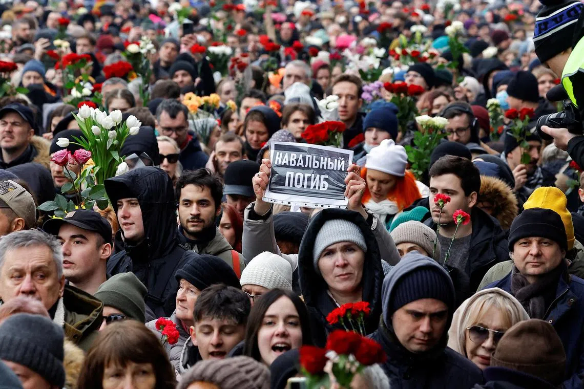People walk towards the Borisovskoye cemetery during the funeral of Russian opposition politician Alexei Navalny in Moscow, Russia, March 1, 2024. A placard reads: \"Navalny died\". REUTERS/Stringer/File Photo