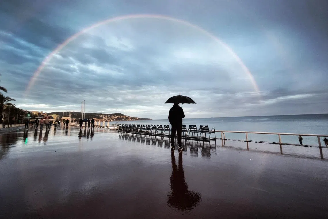 A man looking at a rainbow on the "Promenade des anglais" on the French riviera city of Nice, southern France, on May 1, 2023. 