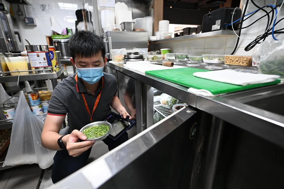 Food safety inspector Ernest Chua demonstrating how he carries out inspections in a restaurant kitchen.  