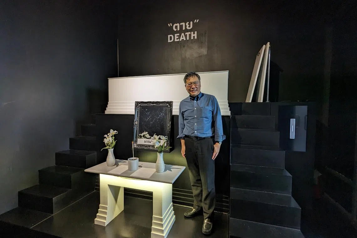 Dr Veeranut Rojanaprapa, a social scientist, opened the  Kid Mai Death Awareness Cafe to get people to think and talk about their mortality. As part of the accompanying exhibit, visitors are encouraged to lie for a few minutes in a white coffin. 