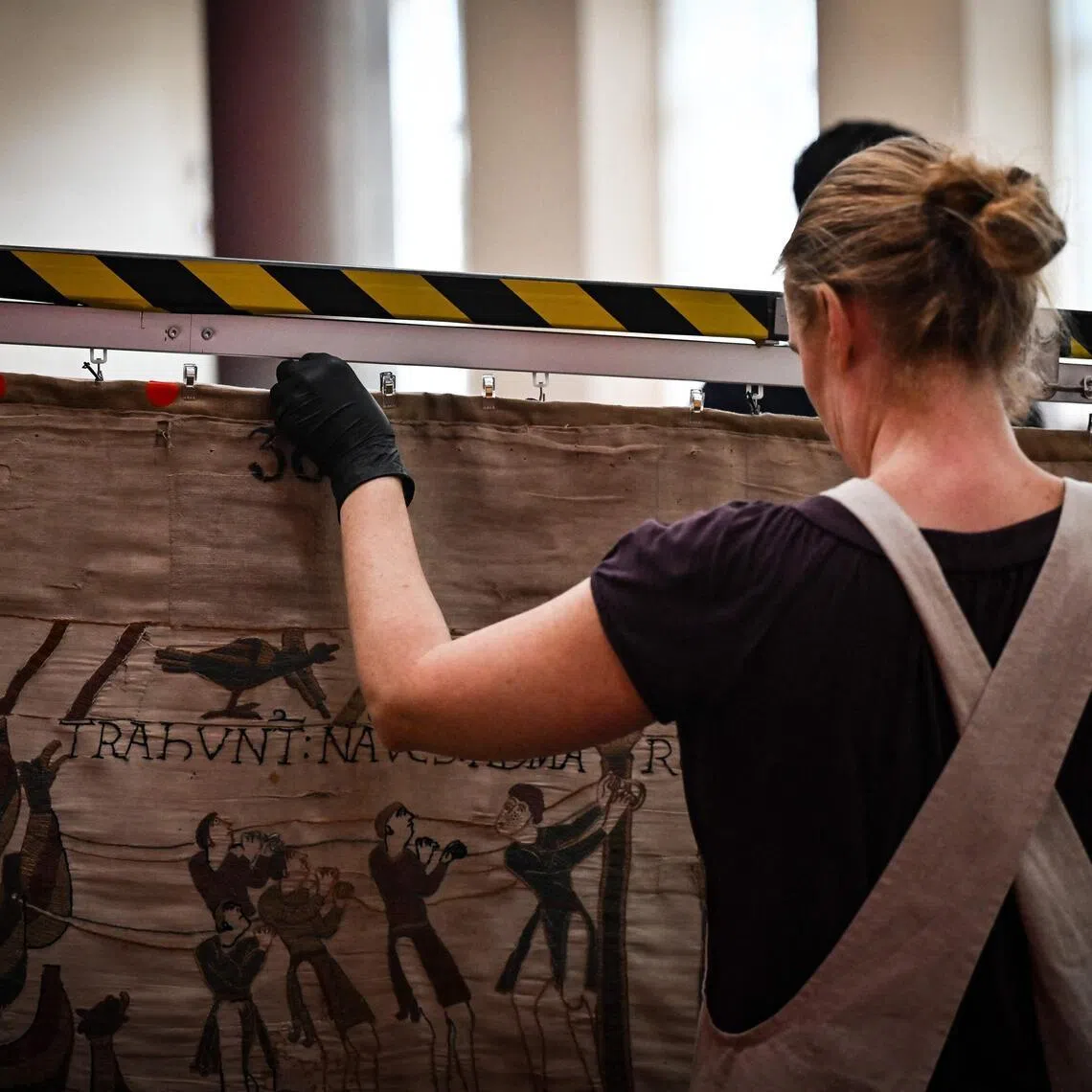 A worker prepares to pack the Bayeux Tapestry in a crate for transfer to the British Museum.