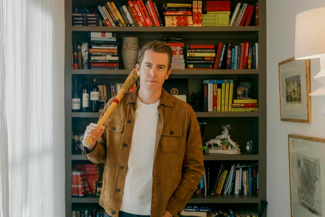 Author David McCloskey with a baseball bat signed by stars from the Cleveland Indians, the same bat that one of his characters, Artemis Aphrodite Procter, keeps in her office.
