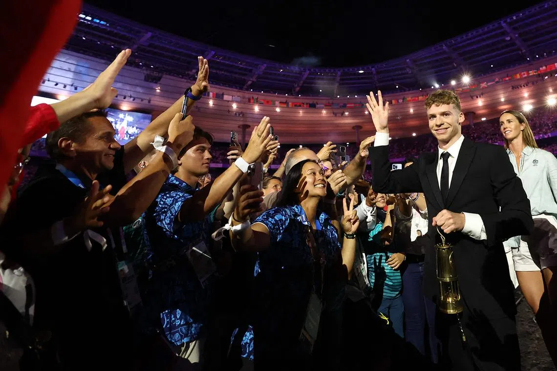 French swimmer Leon Marchand arriving with the Olympic flame during the closing ceremony of the Paris Olympics at the Stade de France on Aug 11, 2024.