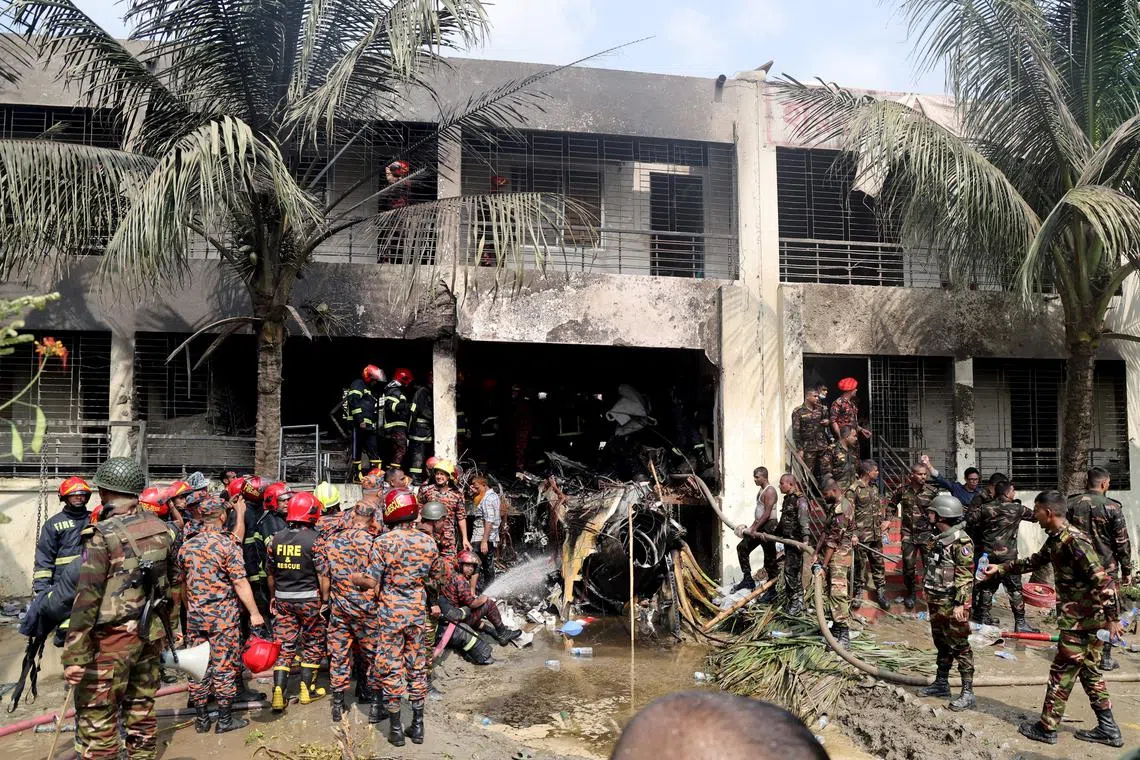 FILE PHOTO: Firefighters and soldiers work next to the wreckage of an air force training aircraft after it crashed into Milestone College campus, in Dhaka, Bangladesh, July 21, 2025. REUTERS/Stringer/File Photo