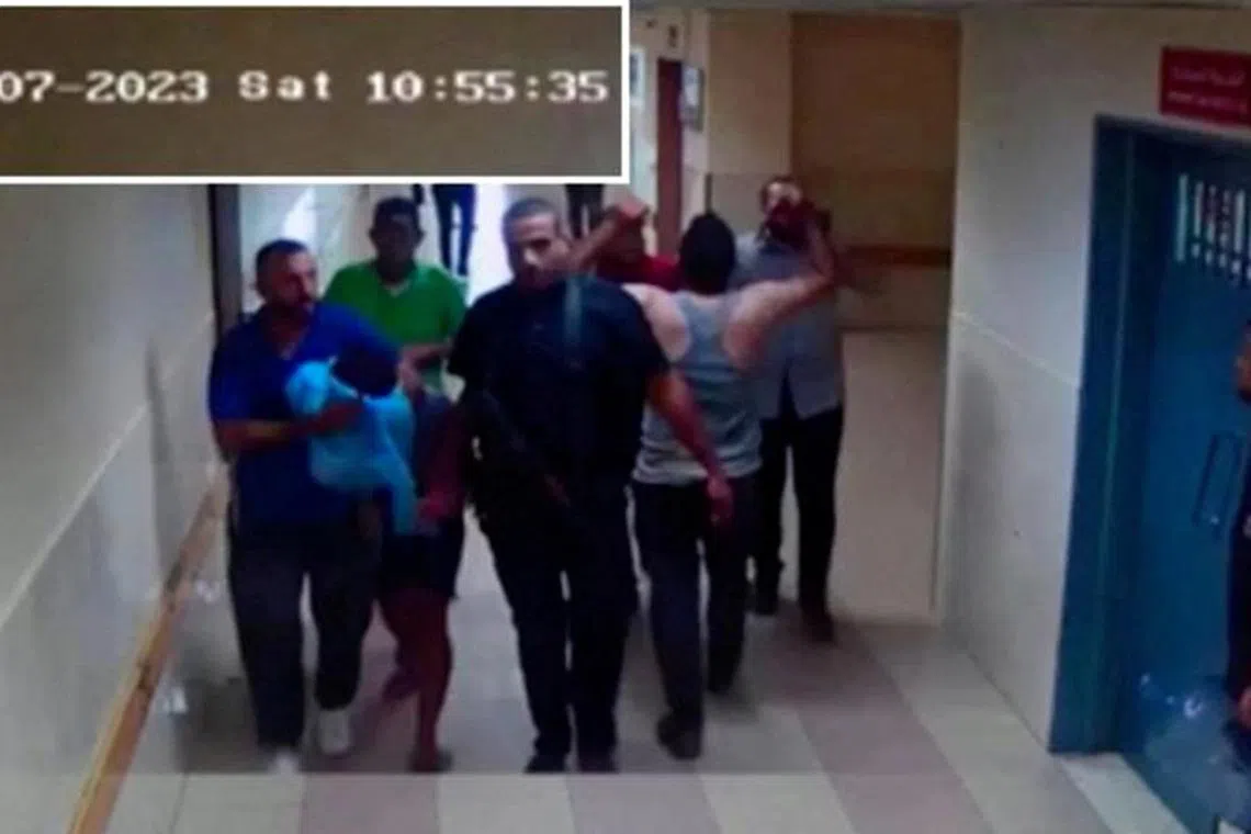 A screen grab of a video released by the Israeli army on November 19, 2023 shows security camera footage of what they say were the Islamic militants of Hamas bringing in a hostage from Israel into the Shifa hospital on the day of the October 7 attack. Israel Defense Forces/Handout via REUTERS