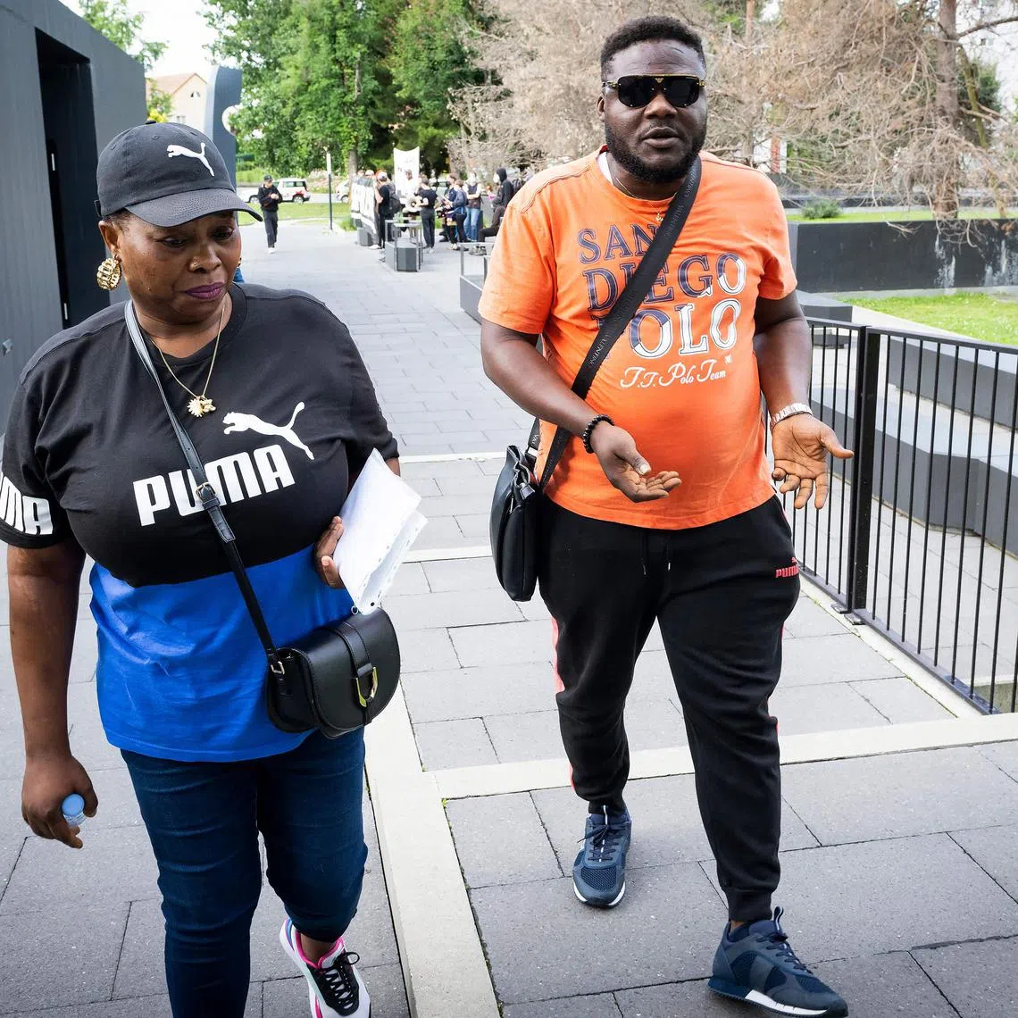 Bridget Efe (left), the widow of Mike Ben Peter, arrives with Ben Peter's brother at the criminal court for the appeal trial.