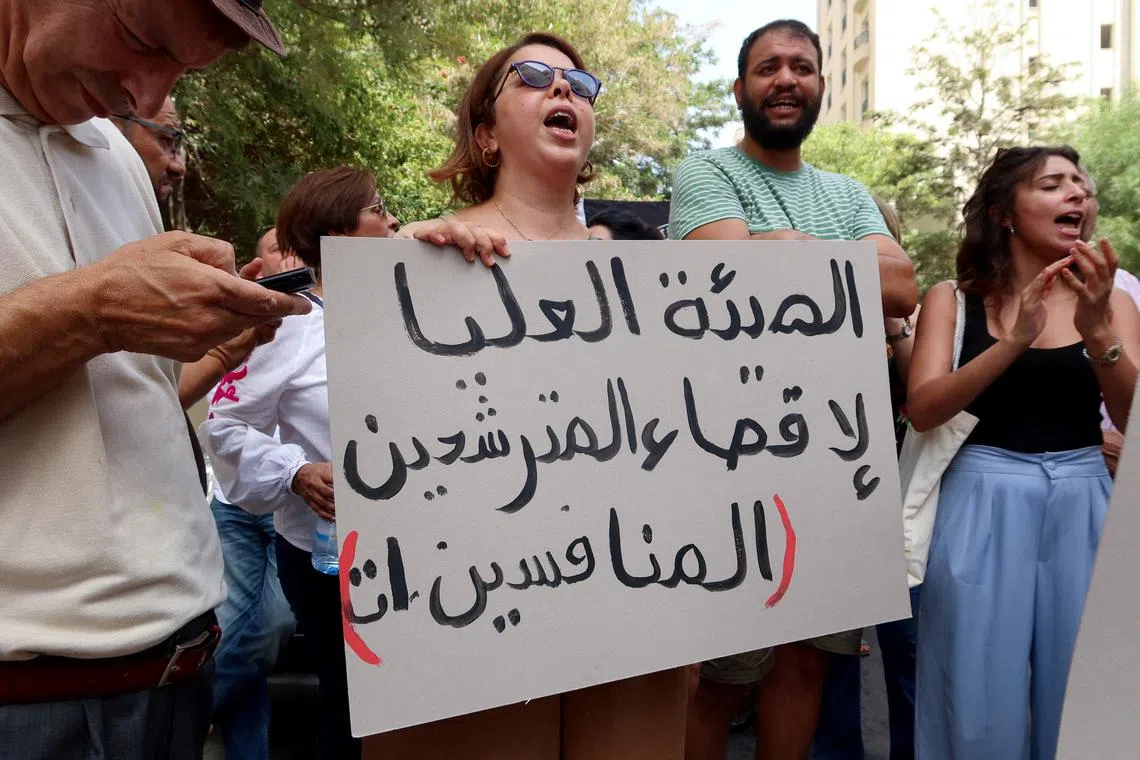 FILE PHOTO: A demonstrator carries a banner during a protest demanding the implementation of a ruling by the administrative court to reinstate three other prominent candidates in the presidential race, near the headquarters of the Electoral Commission in Tunis, Tunisia September 2, 2024. REUTERS/Jihed Abidellaoui/File Photo
