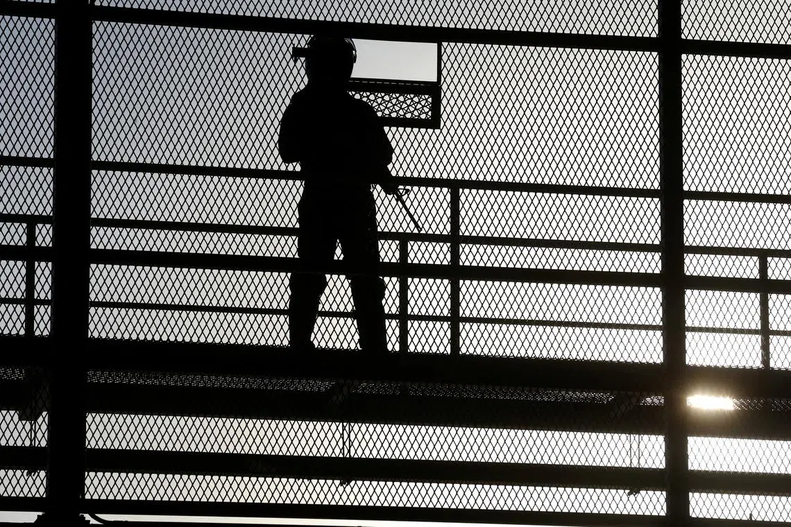 FILE PHOTO: A police officer stands guard, during a media tour at the Terrorism Confinement Center (CECOT) prison, in Tecoluca, El Salvador April 4, 2025. REUTERS/Jose Cabezas/File Photo