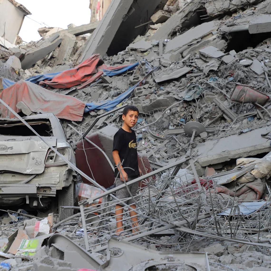 A Palestinian boy stands amidst the rubble as he inspect the site of Israeli strikes on houses at Shati (Beach) refugee camp, amid an Israeli military operation, in Gaza City, September 26, 2025. REUTERS/Ebrahim Hajjaj